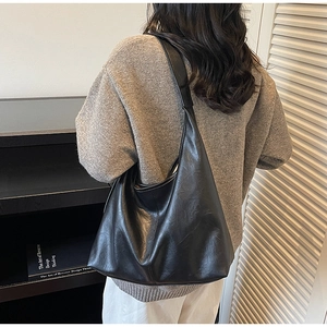 Side view of large black leather tote bag showing spacious design and soft shoulder drape