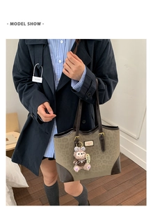 Vista dettagliata della borsa tote leopardata con manici in pelle marrone e ciondolo peluche