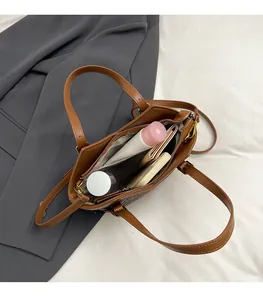 Interior view of brown leather tote bag showing large capacity with various items