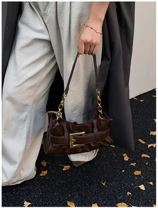 Detail of dark brown pleated bag with vintage gold buckle and metal chain strap