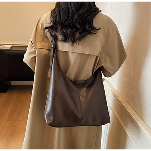 Detail view of deep brown large capacity soft leather Hobo bag worn on the shoulder
