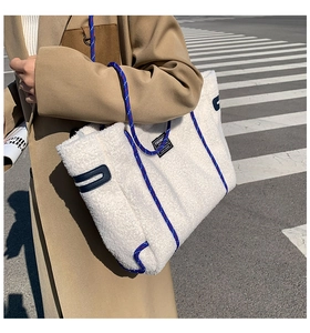 Détail du sac cabas en polaire blanche avec des poignées en corde bleue dans un décor urbain