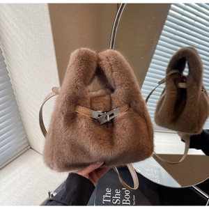 Dettaglio ravvicinato della borsa in peluche marrone con chiusura in metallo e tracolla