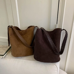 Detail of vintage faux suede bucket bags featuring stylish wide woven shoulder straps