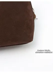 Detail of dark brown suede handbag corner with leather piping and scratch-resistant fabric