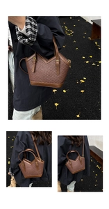Close-up of brown woven tote bag showing texture and leather shoulder strap detail