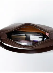 Top view of compact brown baguette bag interior showing spacious storage for daily essentials