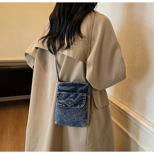 Minimalist denim mobile phone crossbody bag in washed dark blue shown on model