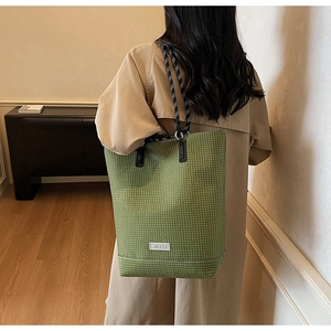Detail view of green checkered canvas tote bag featuring thick rope shoulder straps