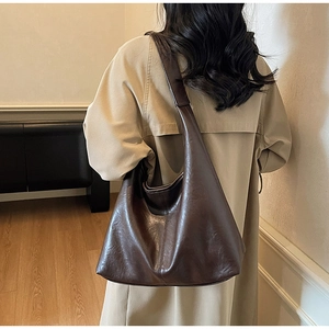 Deep brown large capacity tote bag shown on model highlighting elegant drape and texture