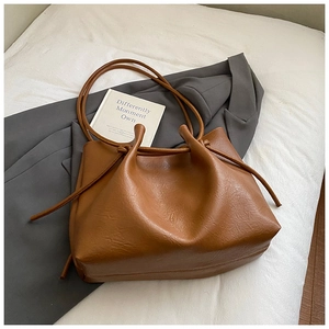 Detail der karamellbraunen Totebag mit Kordelzug-Falten auf weißem Stoffhintergrund