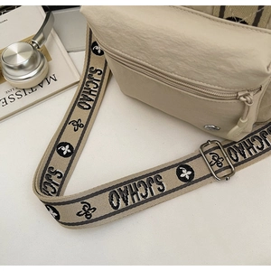 Gros plan d'un sac bandoulière beige en nylon avec sangle SJCHAO et poche zippée avant