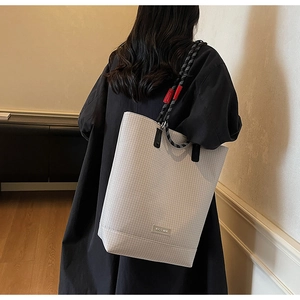 Detail of light grey checkered tote bag featuring contrast rope handles and brand logo