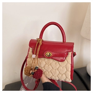 Detail of red leather and beige faux fur handbag with heart texture and golden lock
