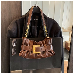 Detail of dark brown baguette bag with golden buckle and chain shoulder strap