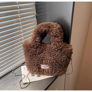 Dettaglio borsa a secchiello in peluche marrone con catena a sfere argento ed etichetta bianca