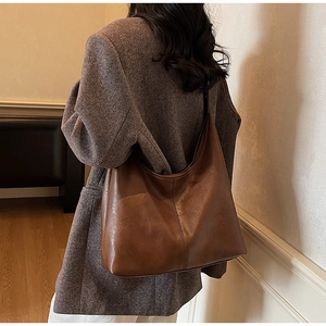 Detailed back view of a dark brown matte leather hobo bag with wide shoulder strap