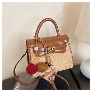 Detail of faux shearling bag with heart pattern, brown patent leather flap and gold lock