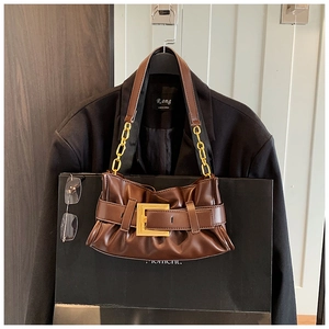 Detail of vintage brown leather underarm bag with large gold buckle and chain strap