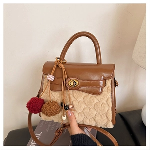 Detail of faux fur crossbody bag featuring heart embossed texture and leather flap cover