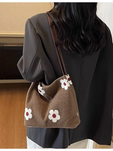 Brown felt tote bag with white daisy embroidery and slim dark leather straps on model