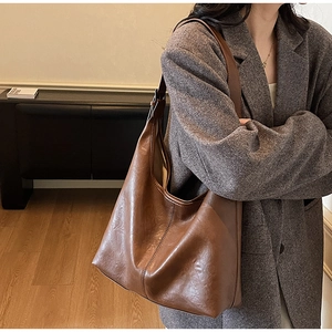 Detail of vintage brown large capacity PU leather hobo bag with natural wrinkled texture