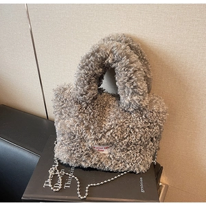 Dettaglio borsa a secchiello in peluche grigio con tracolla a catena ed etichetta