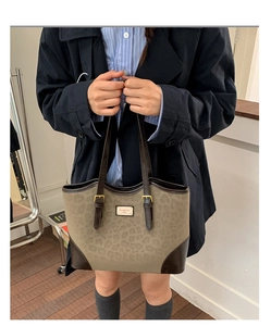Grande borsa tote leopardata indossata da una modella per un look vintage da pendolare