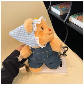 Detail of cute teddy bear plush backpack featuring denim overalls and lace bandana