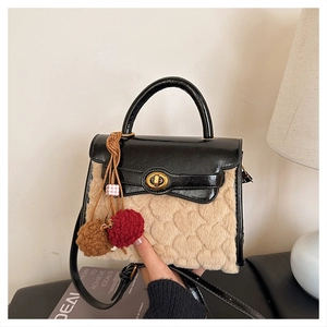 Detail of faux fur crossbody bag with gold twist lock and heart-patterned texture
