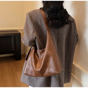 Brown vintage hobo tote bag in premium faux leather texture worn by a model