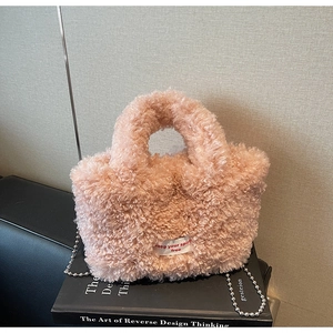 Dettaglio borsa a secchiello rosa in peluche con catena a sfere e etichetta decorativa