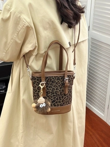 Fashionable leopard print bucket bag with brown leather trim and cute monster charm