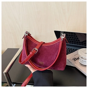 Detailansicht der weinroten Wildledertasche mit silbernen Schnallen und Goldlogo