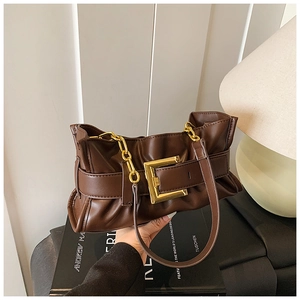 Detail of dark brown pleated leather shoulder bag with gold buckle and chain strap