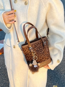 Fashionable leopard print bucket bag with leather handles and plush monster charm