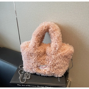 Dettaglio borsa a secchiello in peluche rosa con etichetta e tracolla a catena argento