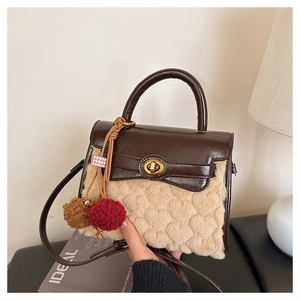 Detail of shearling bag with heart-quilted fur, golden lock and plush ball charms