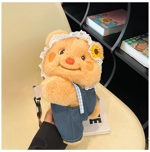 Close-up of cute plush bear backpack wearing denim overalls and a lace hat