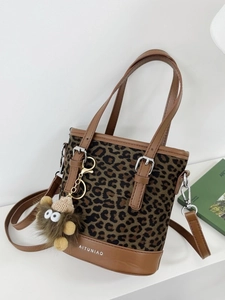 Stylish leopard print bucket bag with brown leather trim and cute lion plush charm