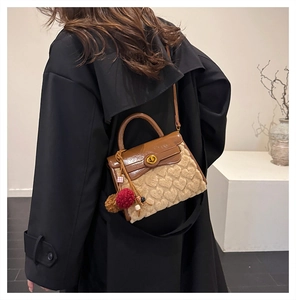 Detail of faux shearling crossbody bag with heart quilting and decorative tassel charms