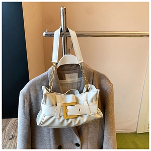 Close-up of white ruched shoulder bag with gold square buckle and metal chain strap
