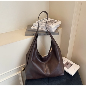 Detail of a deep brown hobo bag with wide adjustable strap and soft matte finish