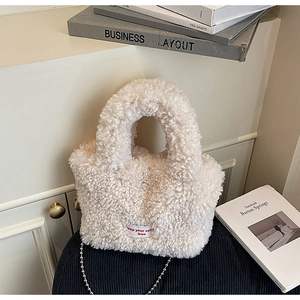 Dettaglio borsa a secchiello in peluche bianca con ricamo keep your spirit free e catena