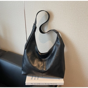 Close-up of the black leather hobo bag with a wide adjustable shoulder strap and metal buckle