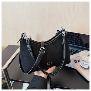 Detail der Materialmischung aus schwarzem Wildleder und Glattleder einer Tasche