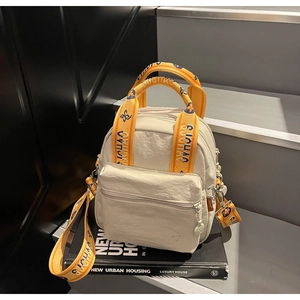 Détail du mini sac en nylon blanc avec bandoulière jaune fleurie et texte brodé