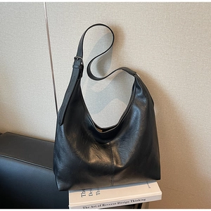 Detail view of large black hobo bag with vintage textured leather and adjustable strap