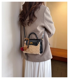 Close-up of fluffy lamb wool handbag with heart-shaped texture and gold twist lock detail