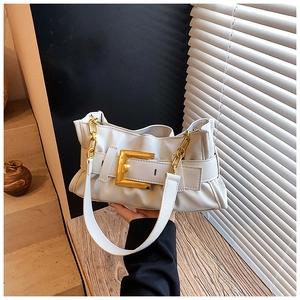 Detail of white pleated shoulder bag with oversized gold buckle and chain accent